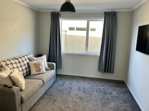 a living room with a couch and a window at Bay Vista - glorious Golden Bay Ocean Views in Pohara