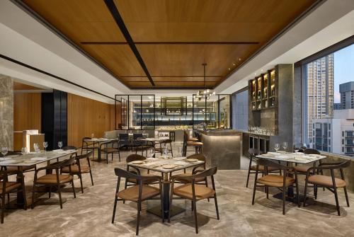 a dining room with tables and chairs and windows at Fairfield by Marriott Mumbai Andheri West in Mumbai