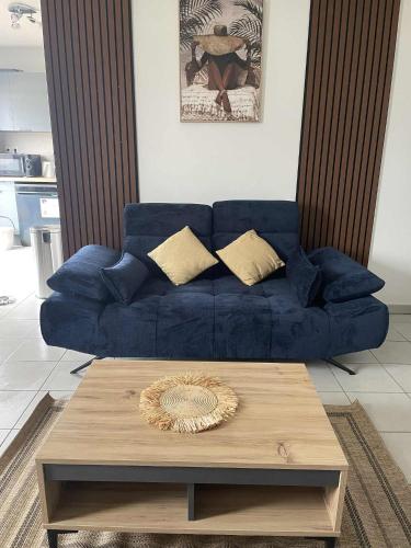 a blue couch in a living room with a coffee table at Evasion du Lagon in Saint-Pierre