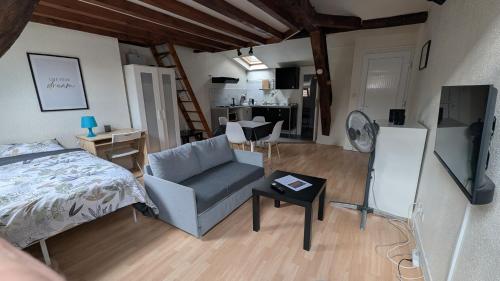 a bedroom with a bed and a chair and a table at L'autunette au quartier historique d'Autun in Autun