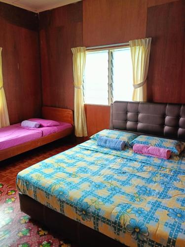 a bedroom with a bed and a window at Bulan And Daud Homestay in Bario