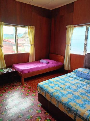 a room with two beds and two windows at Bulan And Daud Homestay in Bario