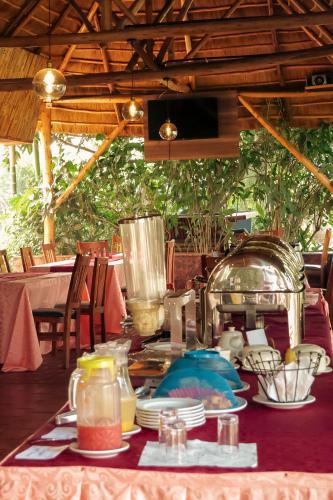 a table with plates of food on top at Nile Bridge Cottages in Jinja