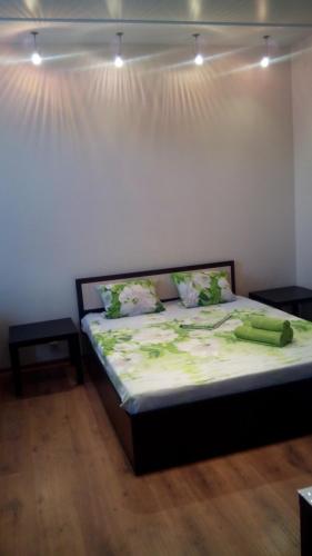 1 dormitorio con 1 cama con sábanas verdes y luces en Apartment on Lenina 44 en Volgogrado