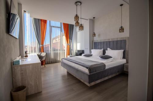 Un dormitorio con una cama grande y una ventana grande. en Hotel Casa Muntenească Alessandro, en Piteşti