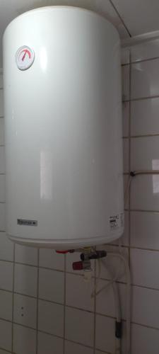 a white water tank on the wall of a bathroom at Felydac Hotel in Yaoundé