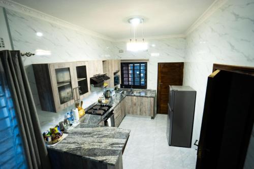 una cucina con ripiani in granito e frigorifero di Modern and cozy apartment a Lusaka