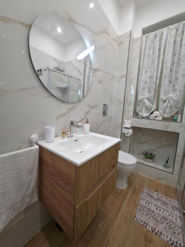 ポッツオーリにあるMaison Luisaの洗面台、鏡、トイレ付きのバスルーム