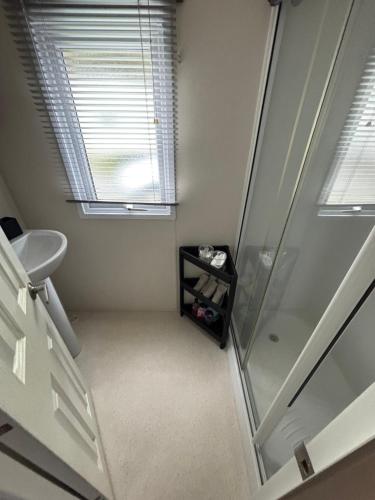 an empty bathroom with a shower and a sink at Modern 2017 model Delta Sienna static caravan in Clarach Bay in Aberystwyth