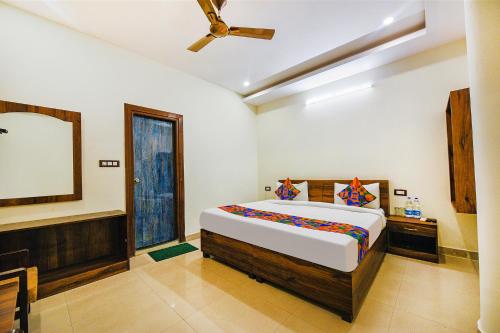 a bedroom with a large bed and a mirror at Hotel Alaknanda Paradise in Dehradun