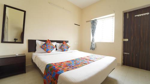 ein Schlafzimmer mit einem Bett mit Spiegel und Fenster in der Unterkunft Union Rooms in Coimbatore