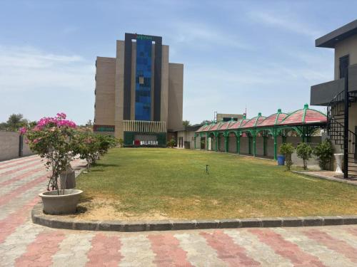 a campus with a building and a field of grass at Hotlel Sanjivani Salasar in Juliāsar