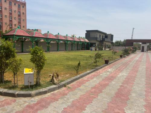 a park with a building in the middle of a field at Hotlel Sanjivani Salasar in Juliāsar