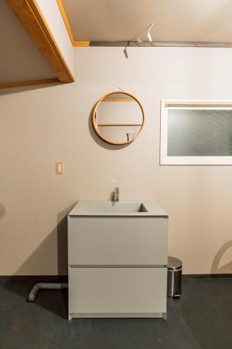a bathroom with a white sink and a mirror at Cabin Build Take - 竹 in Biei