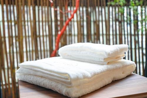una pila di asciugamani bianchi seduti sopra un tavolo di Momotarou Stay a Yokohama