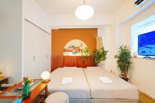 una camera da letto con un letto grande e un tavolo di Momotarou Stay a Yokohama