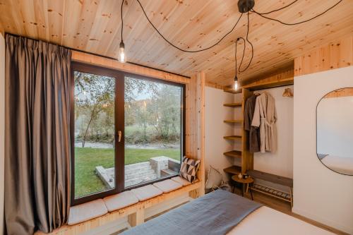 a bedroom with a window in a tiny house at River Escape Retreat & Spa - Adults Only in Avrig