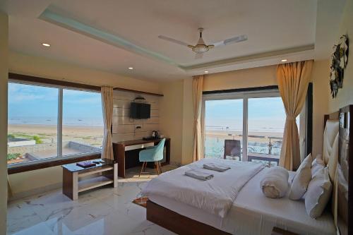 ein Schlafzimmer mit einem Bett mit Blick auf den Strand in der Unterkunft Prasant Beach Resort Mandarmani in Mandarmani