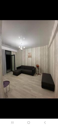 een woonkamer met een bank en een tafel bij Komfort House in Tbilisi City