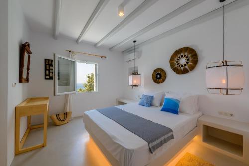 Un dormitorio blanco con una cama y una ventana. en Venti Villa Naxos, en Naxos Chora