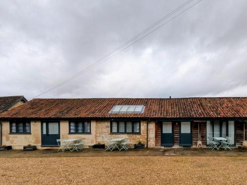 RudloeにあるLower Rudloe Farmの窓とテーブルのある屋根のある家