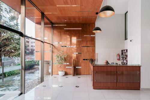 eine Küche mit Holzschränken und einem großen Fenster in der Unterkunft Magnificent ocean view from downtown Viña in Viña del Mar