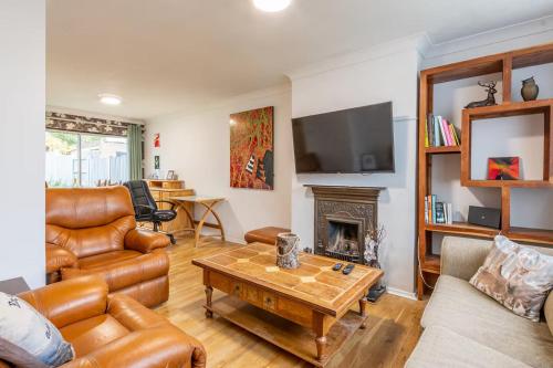 a living room with leather furniture and a fireplace at Pass the Keys 3-Bedroom Home in Chelmsford Sleeps 7 in Great Baddow