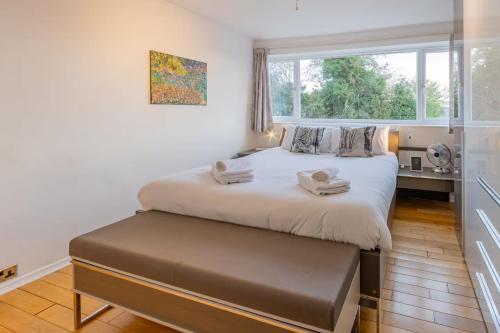 a bedroom with a large bed and a window at Pass the Keys 3-Bedroom Home in Chelmsford Sleeps 7 in Great Baddow