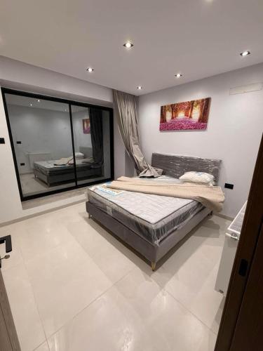 a bedroom with a bed and a large window at Appartement Luxe S2-900m-plage-Fibre-Smart TV-Parking privé in Nabeul