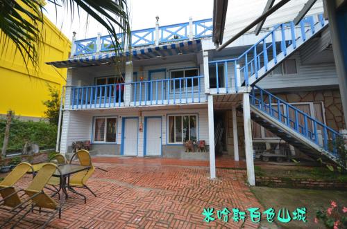 a house with blue stairs and a table and chairs at Cingjing Brilliant Twins of Seattle in Renai