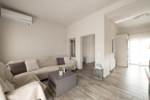 Villa Evanthia في Áyios Yeóryios: غرفة معيشة بيضاء مع أريكة وطاولة