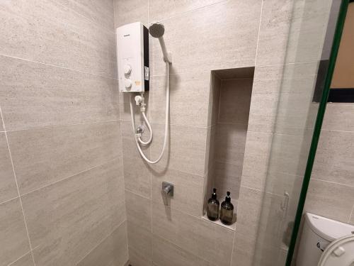 een douche in een badkamer met twee flessen aan de muur bij Subang Studio 6 Pax Home in Subang Jaya