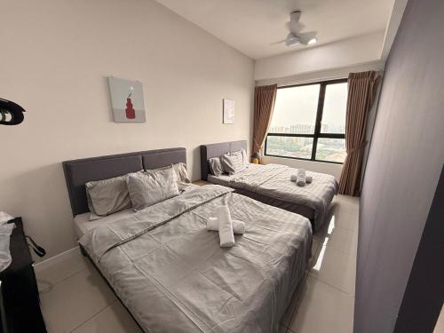twee eenpersoonsbedden in een kamer met een raam bij Subang Studio 6 Pax Home in Subang Jaya