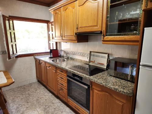 a kitchen with wooden cabinets and a counter top at Rincón de Madagascar VV-2192-AS in Arriondas