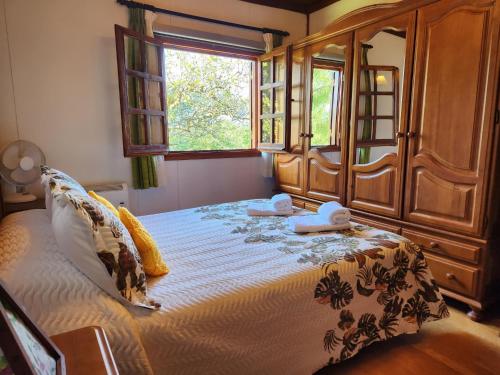 a bedroom with a large bed with a wooden cabinet at Rincón de Madagascar VV-2192-AS in Arriondas