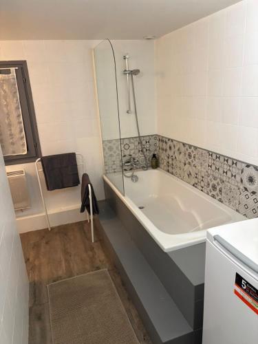 a bathroom with a bath tub and a sink at Le Nid du Sablard in Limoges