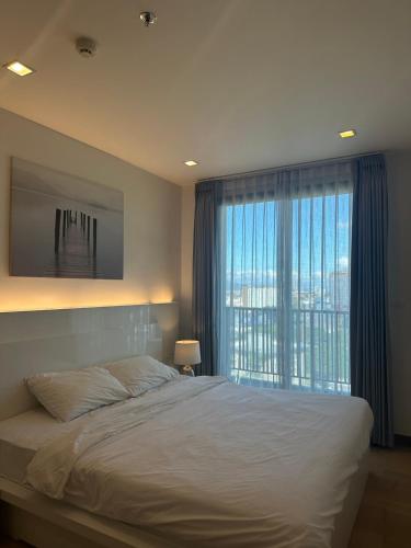 a bedroom with a large bed and a large window at astra sharingla view top floor in Chiang Mai