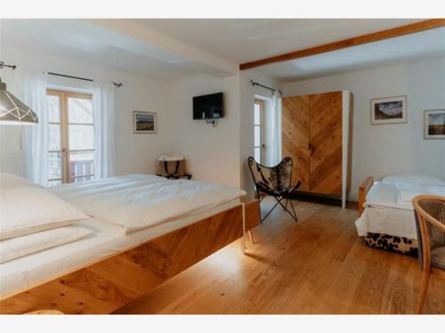 a bedroom with two beds and a chair in it at Villa Palenk Logar Valley in Solčava