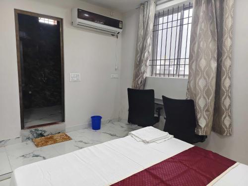 ビラースプルにあるHotel O Luxelineのベッド1台、椅子2脚、テーブルが備わる客室です。