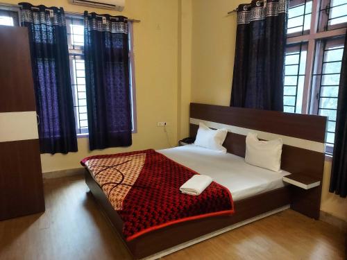 a bedroom with a bed with a red blanket at Hotel O SUNLEAF GUEST HOUSE in Dispur