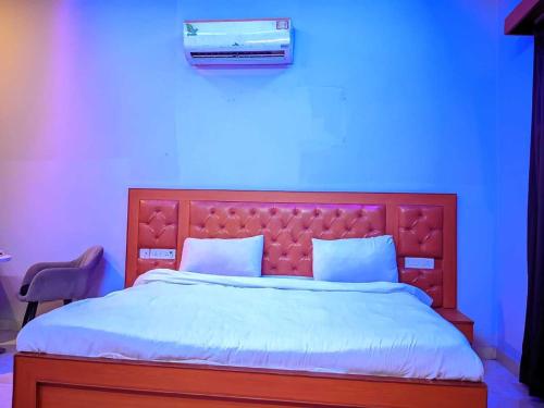 a bedroom with a large bed with a blue background at Hotel O Lavish Hotel in Greater Noida