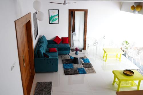 a living room with a blue couch and a table at ll EMPYREAN STAY ll FLAGSHIP INN ll DOUBLE ROOM ll in Lonavala