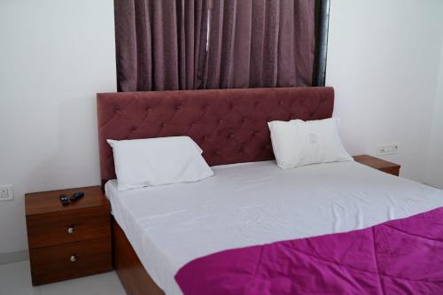 a bedroom with a large bed with a red headboard at ll EMPYREAN STAY ll FLAGSHIP INN ll DOUBLE ROOM ll in Lonavala
