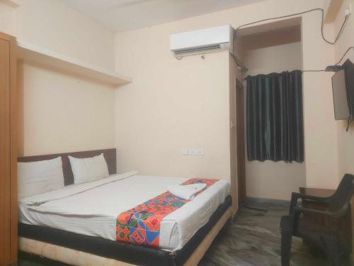 a bedroom with a bed and a chair in it at HOTEL O THE HOTEL TRIYA in Warangal