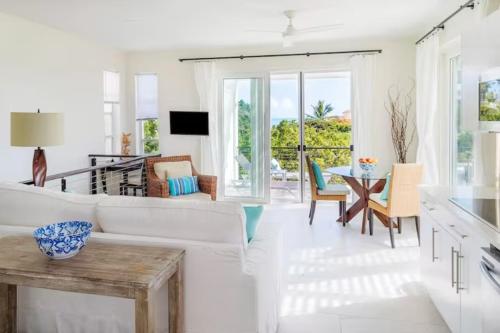 a living room with a white couch and a table at Wyakha Duplex 1 & 2 in Long Bay Hills