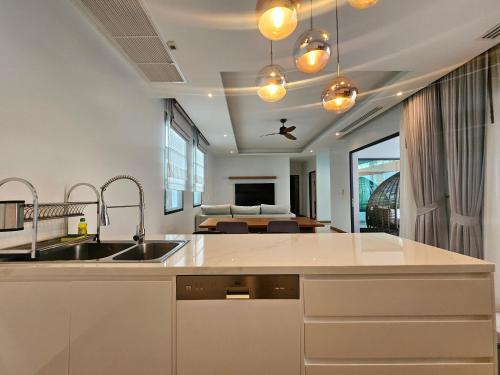 une cuisine avec un évier et un salon dans l'établissement Nicky Villa Luxury Private Haven in BangTao Laguna, à Laguna Phuket
