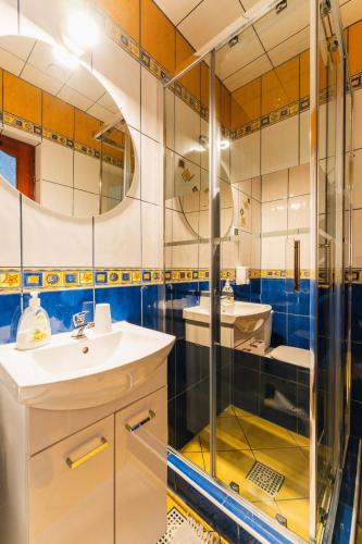a bathroom with a glass shower and two sinks at Willa Józef in Zakopane