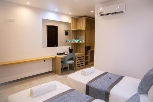 ディグラにあるParadise Foundのベッド2台と机があるホテルの部屋