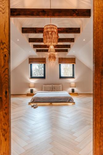 a bedroom with a bed and a chandelier at Sen i Wino, domki i apartament na winnicy ze strefą SPA in Żywiec