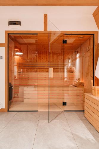a sauna with a glass door in a room at Sen i Wino, domki i apartament na winnicy ze strefą SPA in Żywiec